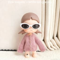 For the Zsiga doll dress it features a stylish pair of sunglasses a pink sweater and a cute design reminiscent of a grandma.