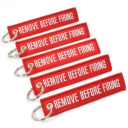 100Pcs “Remove Before Flight” embroidered red fabric keychain with white text – versatile tag for bikes, cars & bags key ring