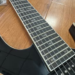 7-String Electric Guitar with Shiny Black High-Gloss Finish and Dual Coil Pickups. Heavy Metal Style. Classic Guitar Shape. Black Fretboard. Embedded Special Pattern Frets. US Warehouse Stock. Free Shipping.