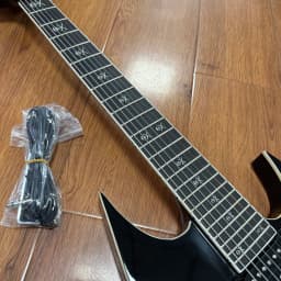 7-String Electric Guitar with Shiny Black High-Gloss Finish and Dual Coil Pickups. Heavy Metal Style. Classic Guitar Shape. Black Fretboard. Embedded Special Pattern Frets. US Warehouse Stock. Free Shipping.