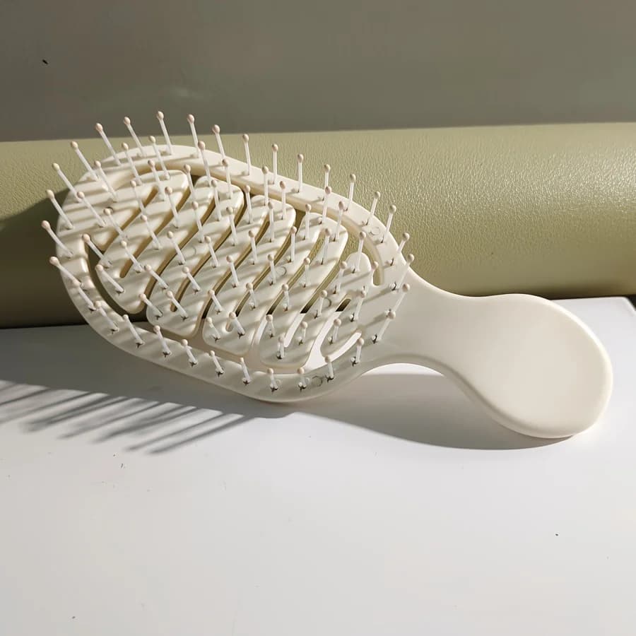 Mini Track Hairbrush, portable hollow design with nylon bristles, ergonomic handle, compact and lightweight—a travel essential.