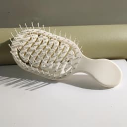 Mini Track Hairbrush, portable hollow design with nylon bristles, ergonomic handle, compact and lightweight—a travel essential.