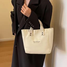 A Casual Canvas Tote Bag with a Bell Pendant and Zipper Closure; This Stylish and Durable Tote Bag Is Perfect for School and Work