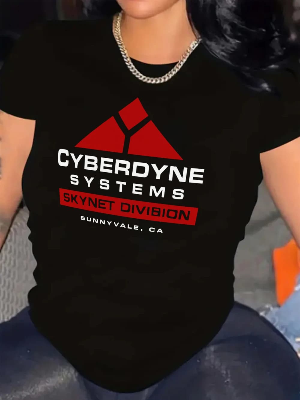 The black T-shirt features a red and white Cybernet system graphic with a triangular design and the word "SKYNET DIVISION" on it