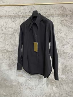 An independent designer of a long, dark leaf-collared shirt