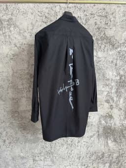 A simple long-sleeved single-breasted shirt with a double-layered collar, solid color and asymmetrical design