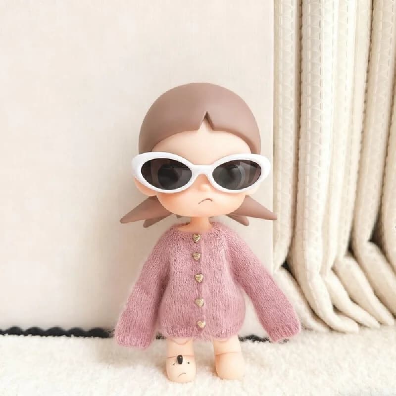 For the Zsiga doll dress it features a stylish pair of sunglasses a pink sweater and a cute design reminiscent of a grandma.