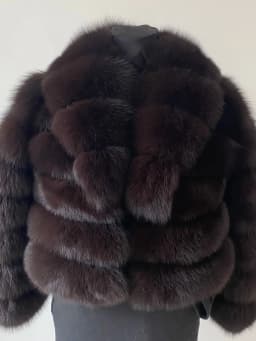 Lady's fashionable warm natural fur coat with a collar for warmth, luxurious high street outerwear