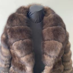 Lady's fashionable warm natural fur coat with a collar for warmth, luxurious high street outerwear