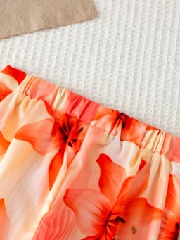 Girls' orange vacation-style two-piece set: a solid-color, ribbed, sleeveless mock-neck crop top paired with lily-print, flowy w