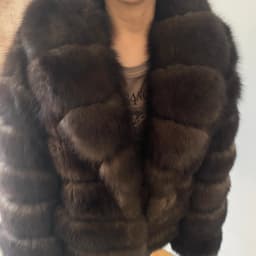 Lady's fashionable warm natural fur coat with a collar for warmth, luxurious high street outerwear